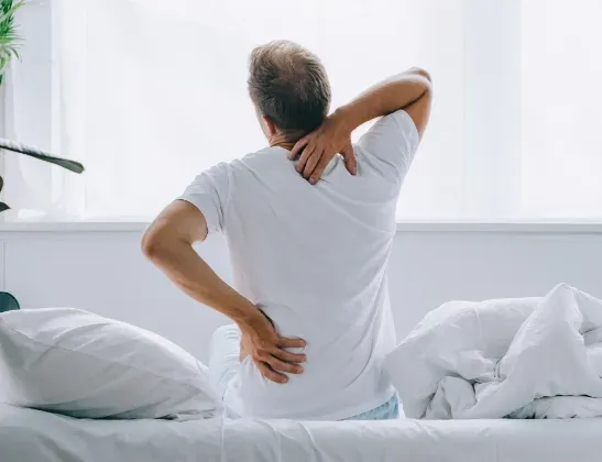 man facing window with intense back pain